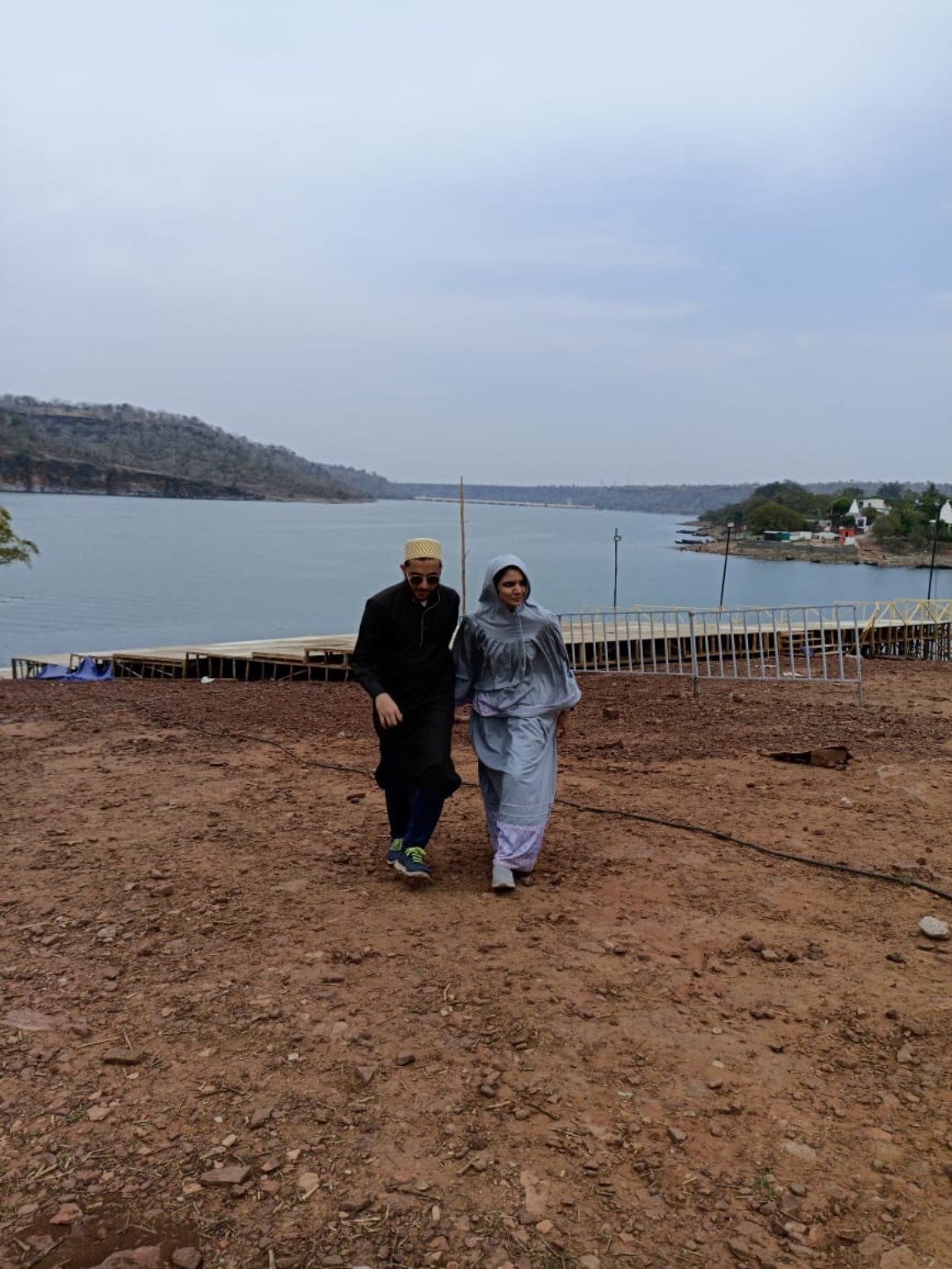 Mariya and Burhanuddin walking near a lake